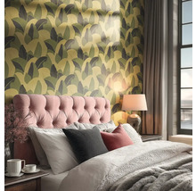 Ložnice s postelí, lampičkou a vzorovanou tapetou