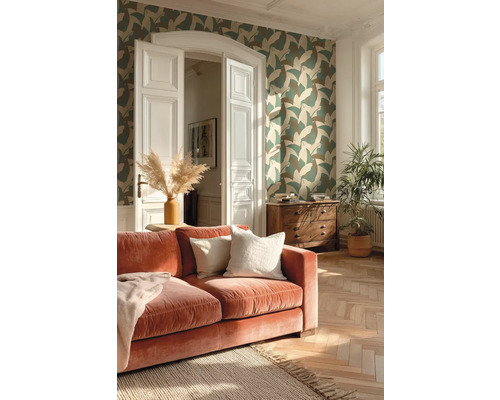 Obývací pokoj s vzorovanou vliesovou tapetou, sametovou pohovkou, parketami se vzorem rybí kosti a dřevěnou komodou.