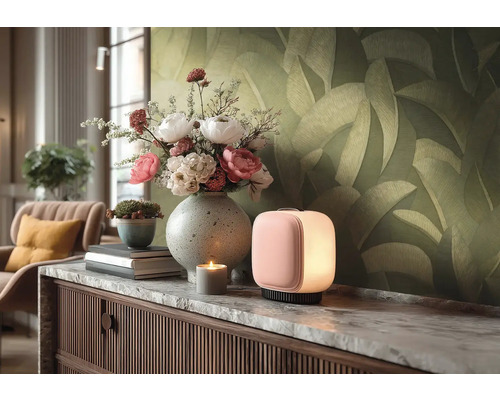 Moderní stolní lampa ve tvaru kvádru s měkkým světlem na komodě s mramorovou deskou, kytice ve váze a tapeta s listovým vzorem.