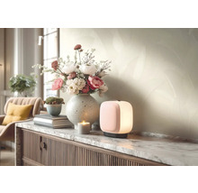 Moderni stolni lampa na komode s mramorovou deskou vedle vazy s kvetinami a svicky ve svetlem, usporadanem obyvacim pokoji.