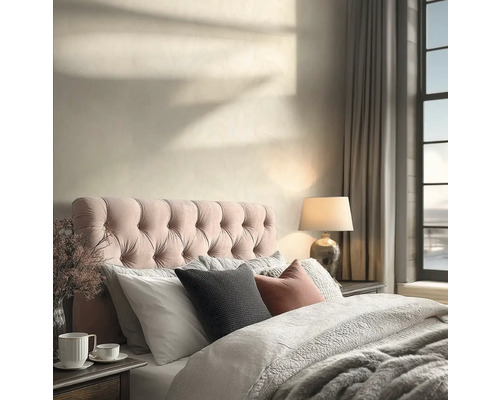 Světlá ložnice s prošívaným čelem postele, texturovaným povlečením, stolní lampou a stíny slunečního světla na zdi.