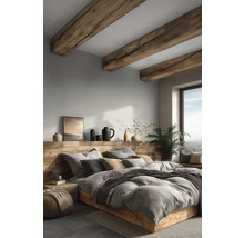 Moderní ložnice s rustikálními dřevěnými trámy, postelí z masivu, světle šedou strukturovanou tapetou a dekoracemi na dřevěné polici.