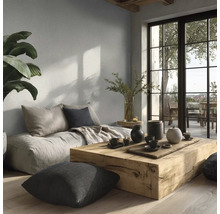 Moderní obývací pokoj se světle šedou barvou na stěně, masivním dřevěným stolem, podsedáky a velkým oknem na balkon.