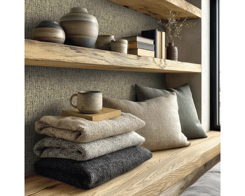 Útulný čtecí koutek s polštáři, přikrývkami a dekoracemi na dřevěných policích