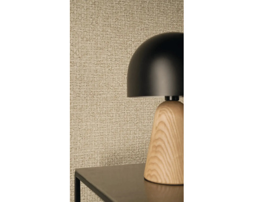 Moderní stolní lampa s černým kulatým stínidlem a dřevěným podstavcem před strukturovanou tapetou s tkaným vzorem.