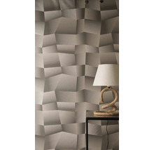 Tapeta s trojrozměrným geometrickým vzorem a strukturovaným povrchem, se stolní lampou s provazovou základnou na odkládacím stolku.