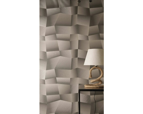 Tapeta s trojrozměrným geometrickým vzorem a strukturovaným povrchem, se stolní lampou s provazovou základnou na odkládacím stolku.