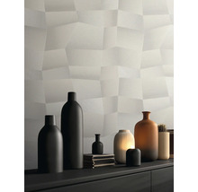 Moderní strukturovaná tapeta s trojrozměrným polygonálním vzorem ve světle šedé barvě, dekorovaná vázami na komodě.