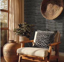 Tmavě šedá tapeta se vzhledem kamene v rustikálně zařízeném obývacím pokoji s dřevěným křeslem, terakotovou vázou a pokojovou rostlinou.