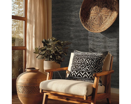 Tmavě šedá tapeta se vzhledem kamene v rustikálně zařízeném obývacím pokoji s dřevěným křeslem, terakotovou vázou a pokojovou rostlinou.