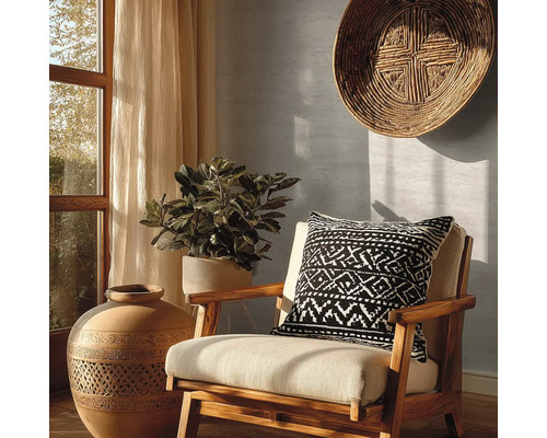 Dekorativní interiér s židlí, polštářem s geometrickým vzorem, velkou vázou a pokojovou rostlinou.