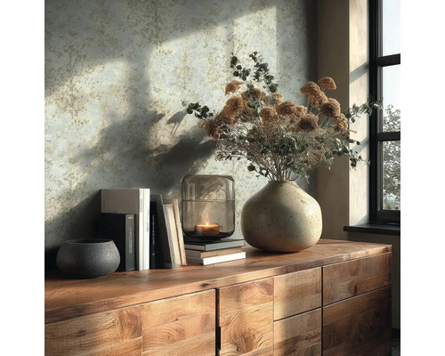 Dekorativní zátiší s vázou, svíčkou a knihami na dřevěné komodě před vzorovanou stěnou