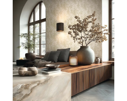 Světlý obývací pokoj se vzorovanou tapetou, nástěnnou lampou, dřevěným sideboardem s lamelami a velkou kamennou vázou s větvemi.