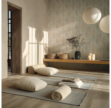 Světlý jógový sál se šedými podložkami na dřevěné podlaze, polštáři, ručníky, dřevěnou lavicí a kulatými papírovými lampami.