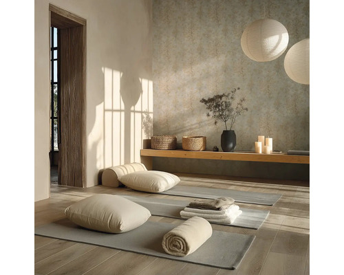 Světlý jógový sál se šedými podložkami na dřevěné podlaze, polštáři, ručníky, dřevěnou lavicí a kulatými papírovými lampami.