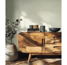 Světlá strukturovaná tapeta ve světlé místnosti s dřevěnou komodou, keramickou vázou a parketami.