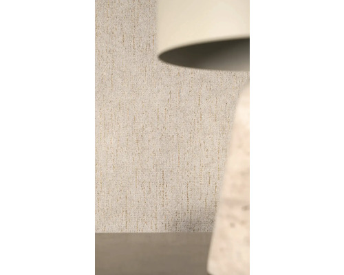 Strukturovaná vliesová tapeta s vertikálním vzorem a třpytivým efektem za lampou.