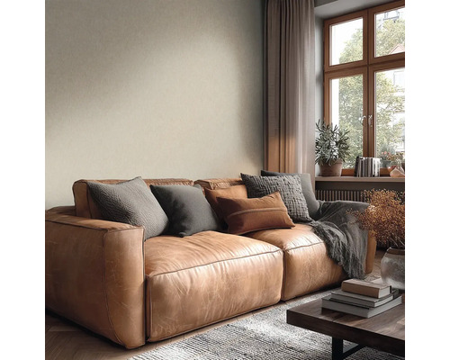 Útulný obývací pokoj s hnědou koženou pohovkou, polštáři, béžovou strukturovanou tapetou a dřevěným oknem.