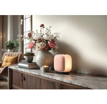 Moderní přenosná LED lampa, kamenná váza s květinami a svíčka na komodě s mramorovou deskou ve světlém interiéru.