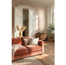 Obývací pokoj s oranžovou pohovkou, dřevěnou podlahou a komodou