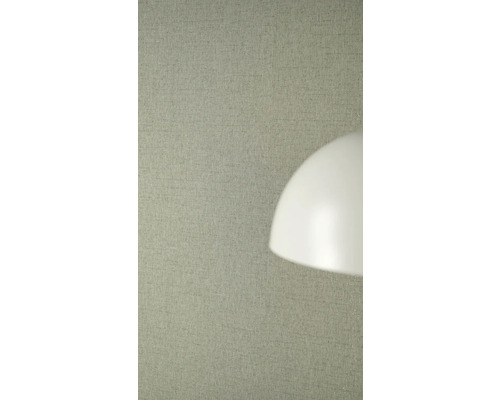 Strukturovaná vliesová tapeta se lněným vzhledem na stěně za stínidlem lampy.