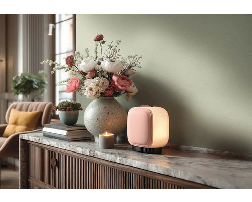 Moderní scéna obývacího pokoje s rozsvícenou přenosnou stolní lampou a velkou vázou s květinami na komodě s mramorovou deskou.