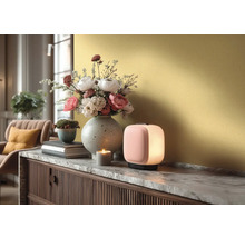 Moderní stolní lampa na komodě s mramorovou deskou, vedle váza s květinami, malý květináč a zapálená svíčka.