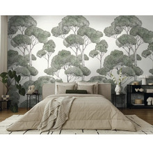 Ložnice s nástěnnou tapetou s motivem stromů za postelí.