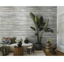 Obývací pokoj s pohovkou, pokojovými rostlinami a stěnou se strukturovanou tapetou