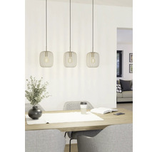 Tři kovová závěsná svítidla nad jídelním stolem s dekorací a židlemi.