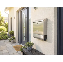 Nerezová poštovní schránka na stěně domu vedle vchodových dveří