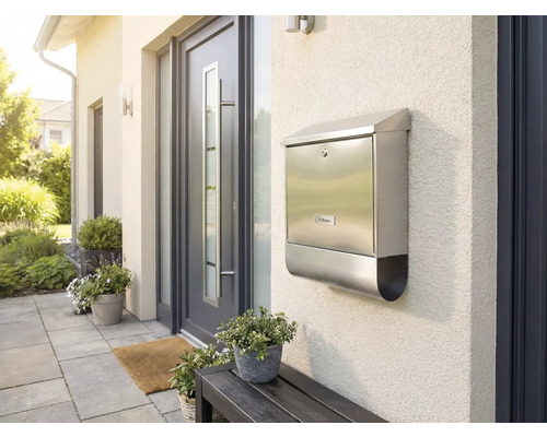 Nerezová poštovní schránka na stěně domu vedle vchodových dveří