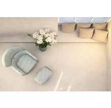 Světlá místnost s křeslem, podnožkou, květinovou vazbou a pohovkou s polštáři, pohled shora