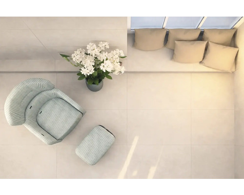 Světlá místnost s křeslem, podnožkou, květinovou vazbou a pohovkou s polštáři, pohled shora