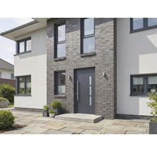 Moderní dům s šedými cihlami, vchodovými dveřmi a okny