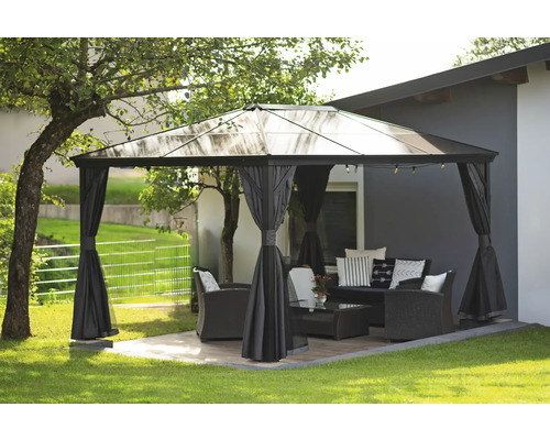 Zahradní scéna s altánem, sedací soupravou a dekorací na trávníku.