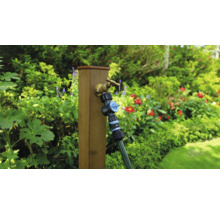 Zahradní scéna s vodovodním kohoutkem, rozdělovačem a hadicí na dřevěném sloupku