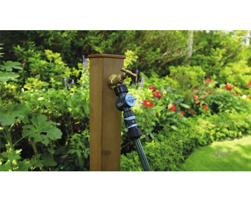 Zahradní scéna s vodovodním kohoutkem, rozdělovačem a hadicí na dřevěném sloupku