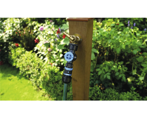 Zahradní scéna s vodovodním kohoutkem na dřevěném sloupku a připojenou zahradní hadicí