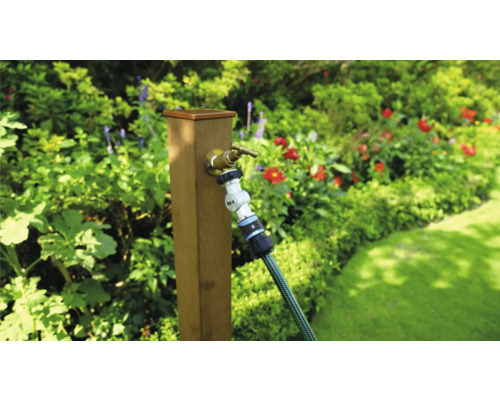 Zahradní scéna s vodovodním kohoutkem a zahradní hadicí na dřevěném sloupku