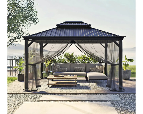 Altán s moskytiérou, pohovkou a stolem na zahradě.