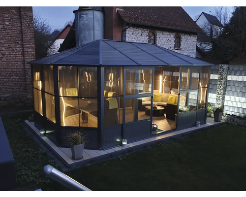 Vnější pohled na zahradní pavilon s nábytkem v zahradě.