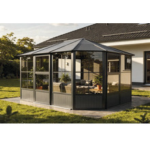 Volně stojící pavilon se skleněnými stěnami a zahradním nábytkem na trávníku.