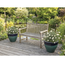 Zahradní scéna s dřevěnou lavicí, jezírkem a květinami v květináčích na dřevěné terase