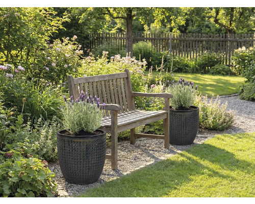 Zahradní krajina s dřevěnou lavicí a rostlinami ve strukturovaných květináčích