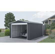 Velká kovová garáž v antracitové barvě s bílým rámem a sedlovou střechou, s bočním vchodem a zaparkovaným autem na dlážděné příjezdové cestě.