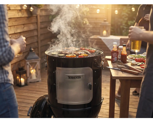 Udírna s masem a zeleninou na grilovací mřížce na zahradní grilovačce.