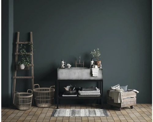 Interiér koupelny s umyvadlem, žebříkem, košíky a ručníky