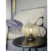 Zlatá drátěná kulová lampa na stole v ložnici