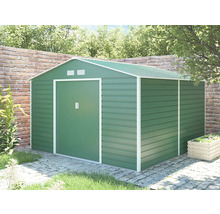 Kovový zahradní domek v zelené barvě se sedlovou střechou a posuvnými dveřmi, umístěný v zahradě na dlažbě před cihlovou zdí.